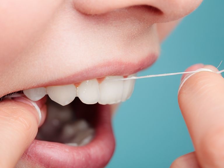 Bạn dùng chỉ nha khoa để lấy hết mảng bám trong răng sau khi ăn