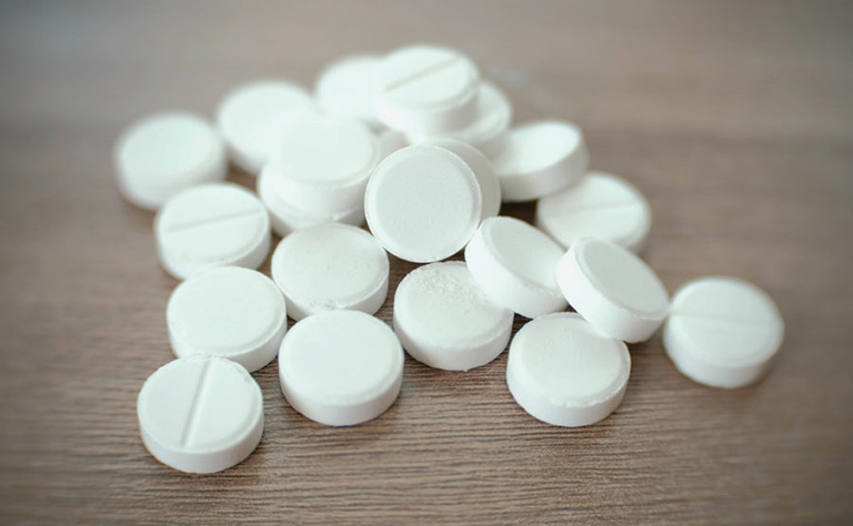 Pile of round white tablets on the table.